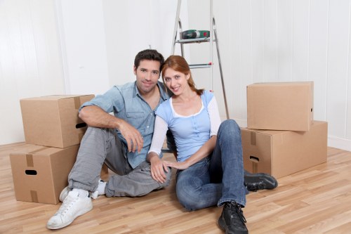 Movers carrying furniture through a Fulham flat entrance